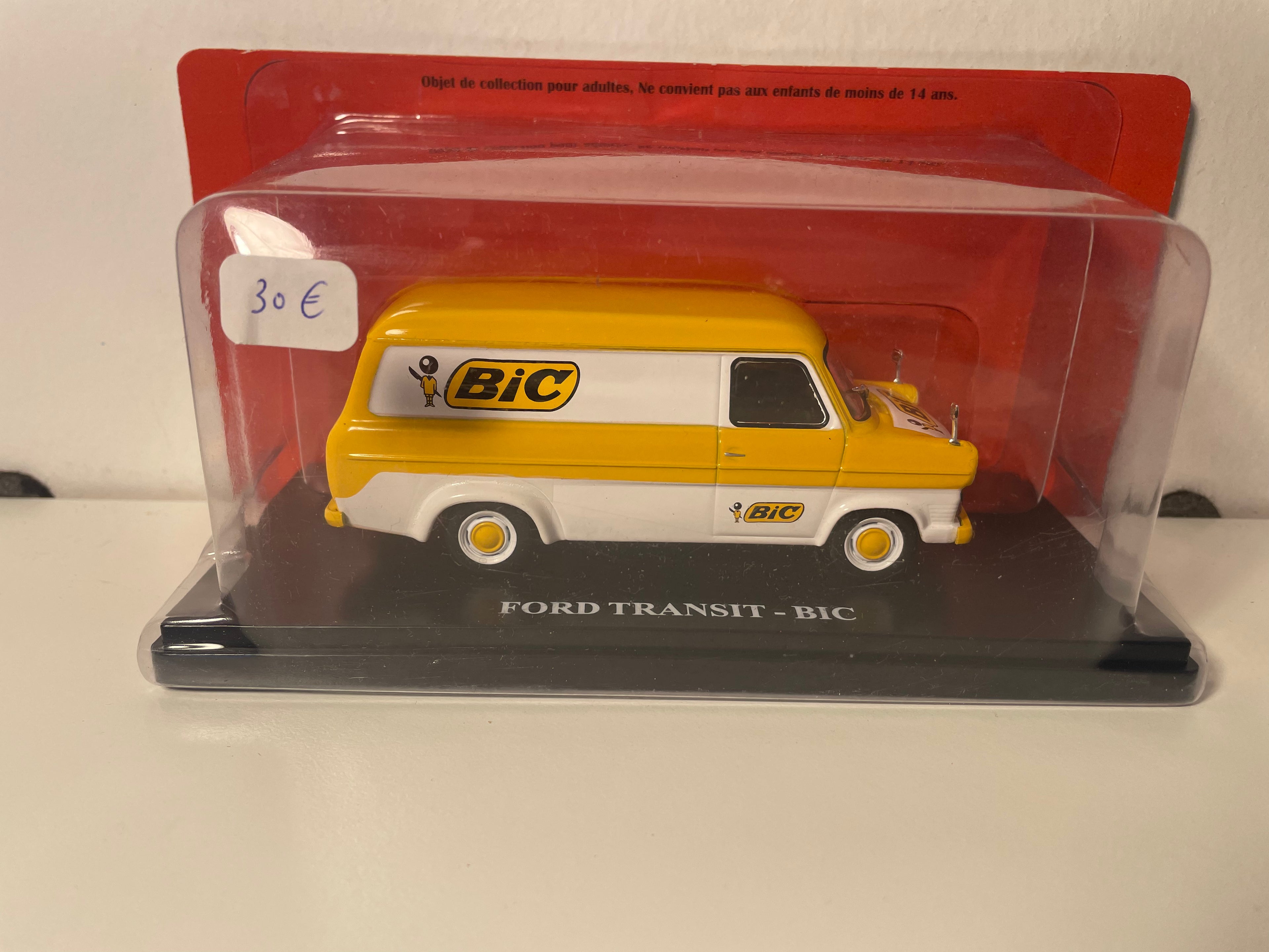 Ford Transit amarillo y blanco con publicidad BIC