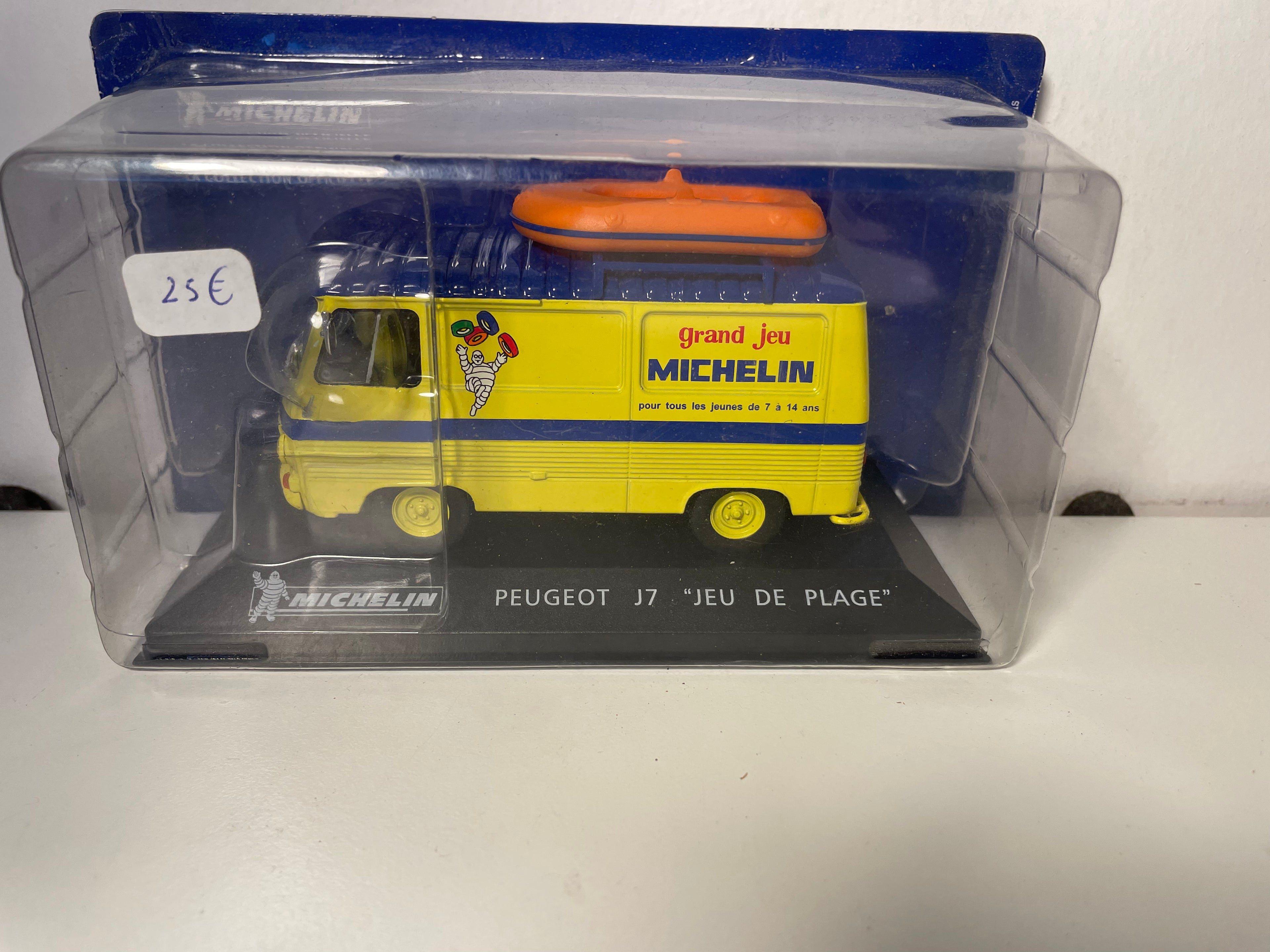 Peugeot J7 de plage jaune et toit bleu avec barque sur le toit MICHELIN