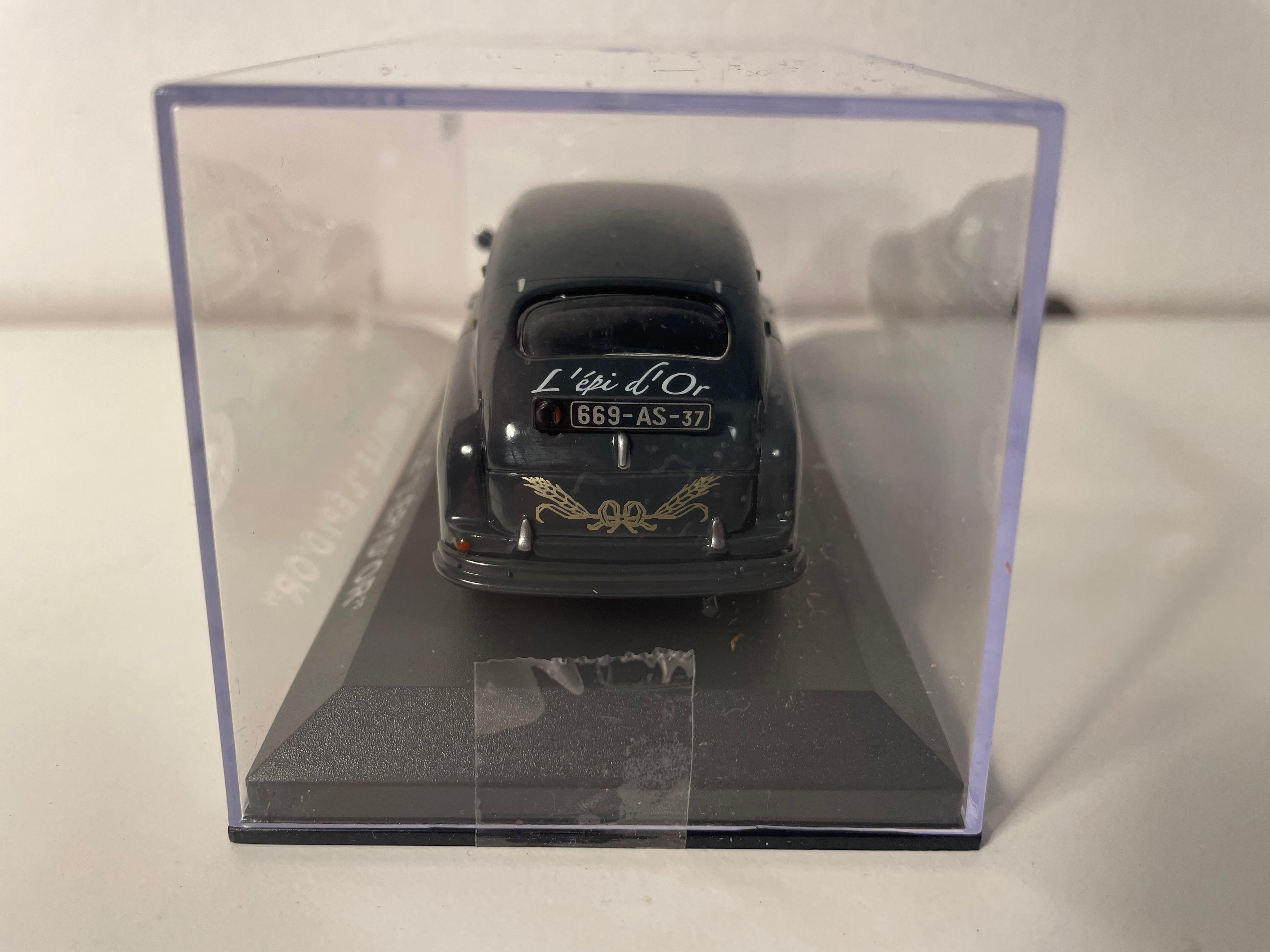Ford Bee gris oscuro con publicidad de L'EPI D'OR