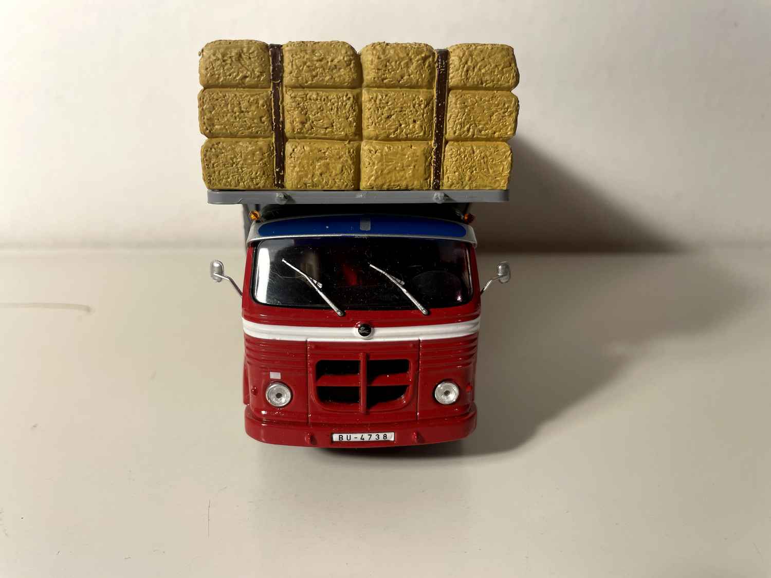 Ciężarówka Pegaso Comet z 1964 r. (czerwona kabina i szara, słomiana platforma transportowa)