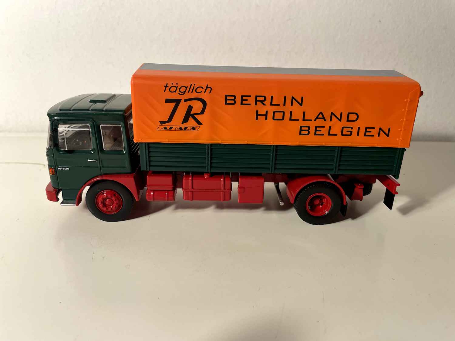 Man Büssing Unterflur truck from 1975 with green platform and orange "Holland" tarpaulin