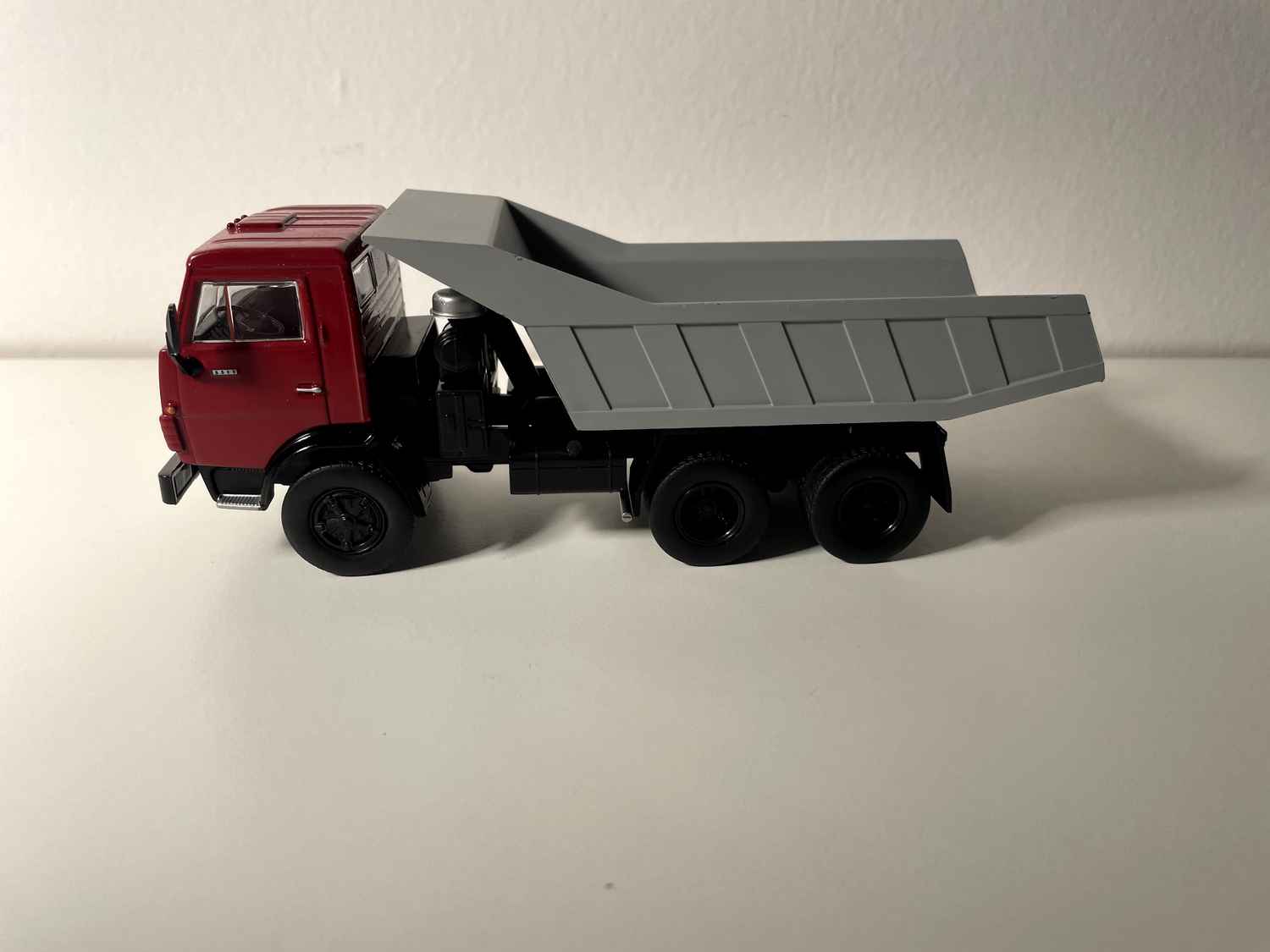 Camión volquete Kamaz 5511 con cabina roja y caja gris (URSS 1976)