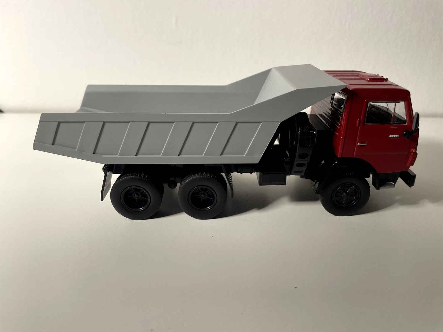 Camión volquete Kamaz 5511 con cabina roja y caja gris (URSS 1976)