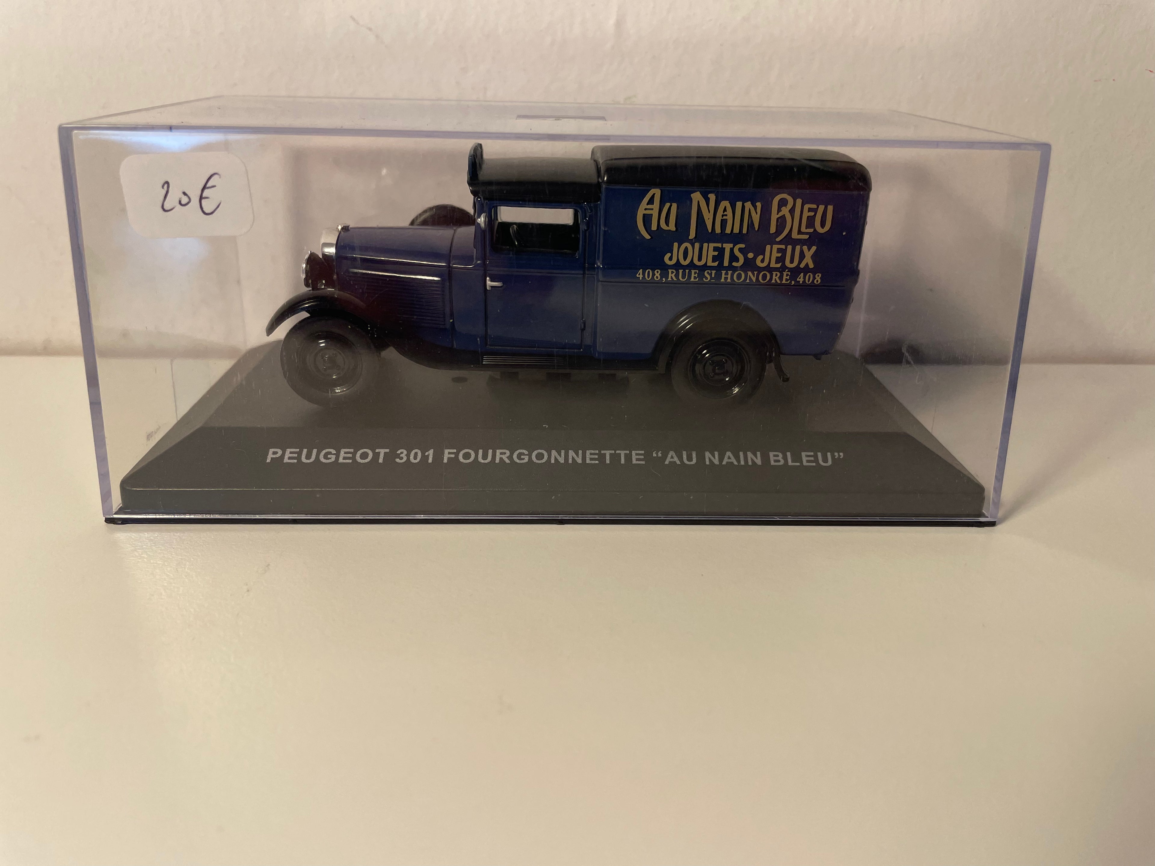 Peugeot 301 blauwe bestelwagen met zwart dak - Advertentie voor de speelgoedwinkel "AU NAIN BLEU" in Parijs