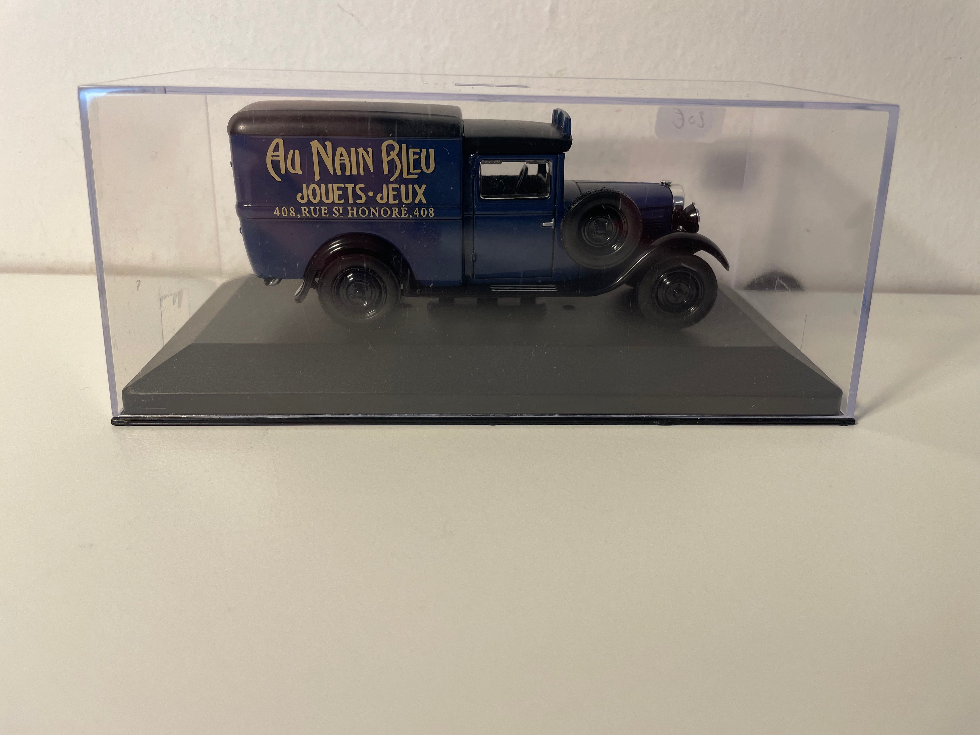 Peugeot 301 blauwe bestelwagen met zwart dak - Advertentie voor de speelgoedwinkel "AU NAIN BLEU" in Parijs