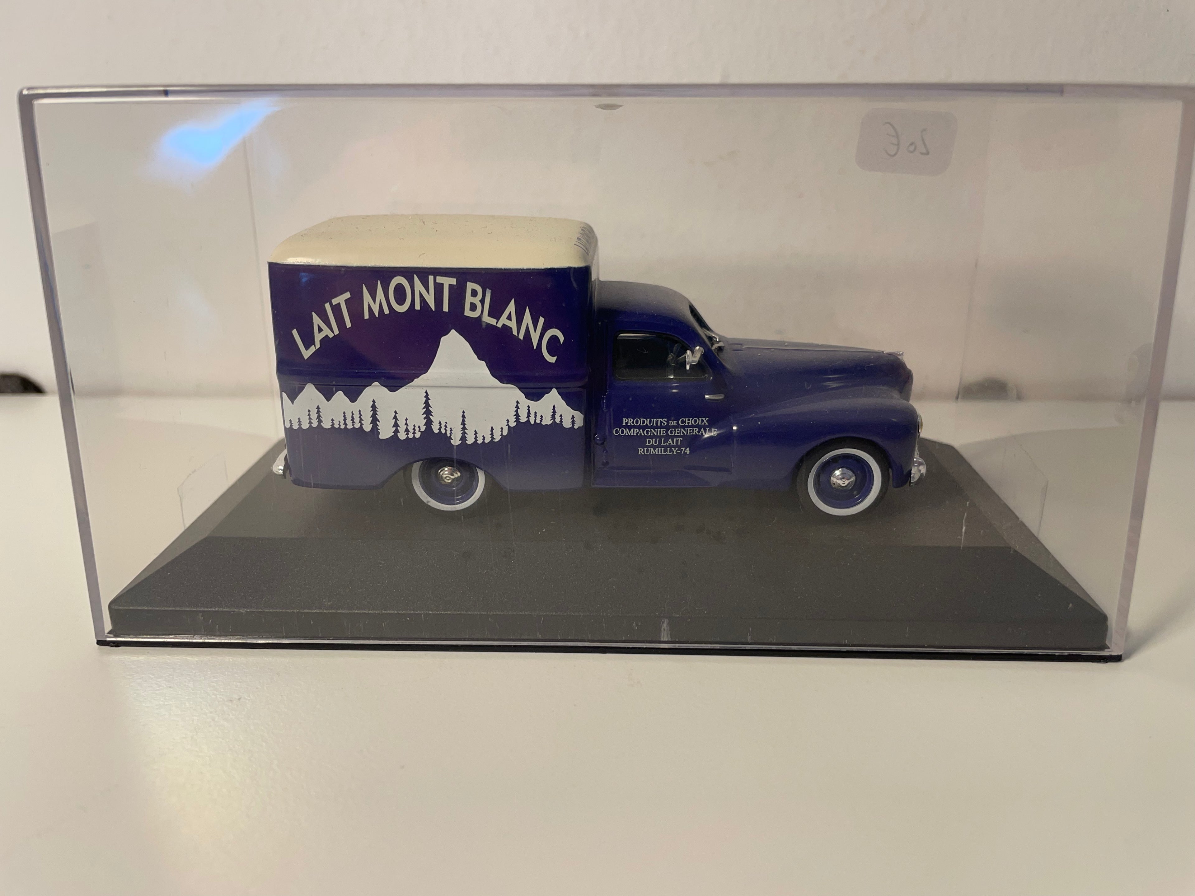 Peugeot 203 C8 azul con publicidad de Lait Mont Blanc