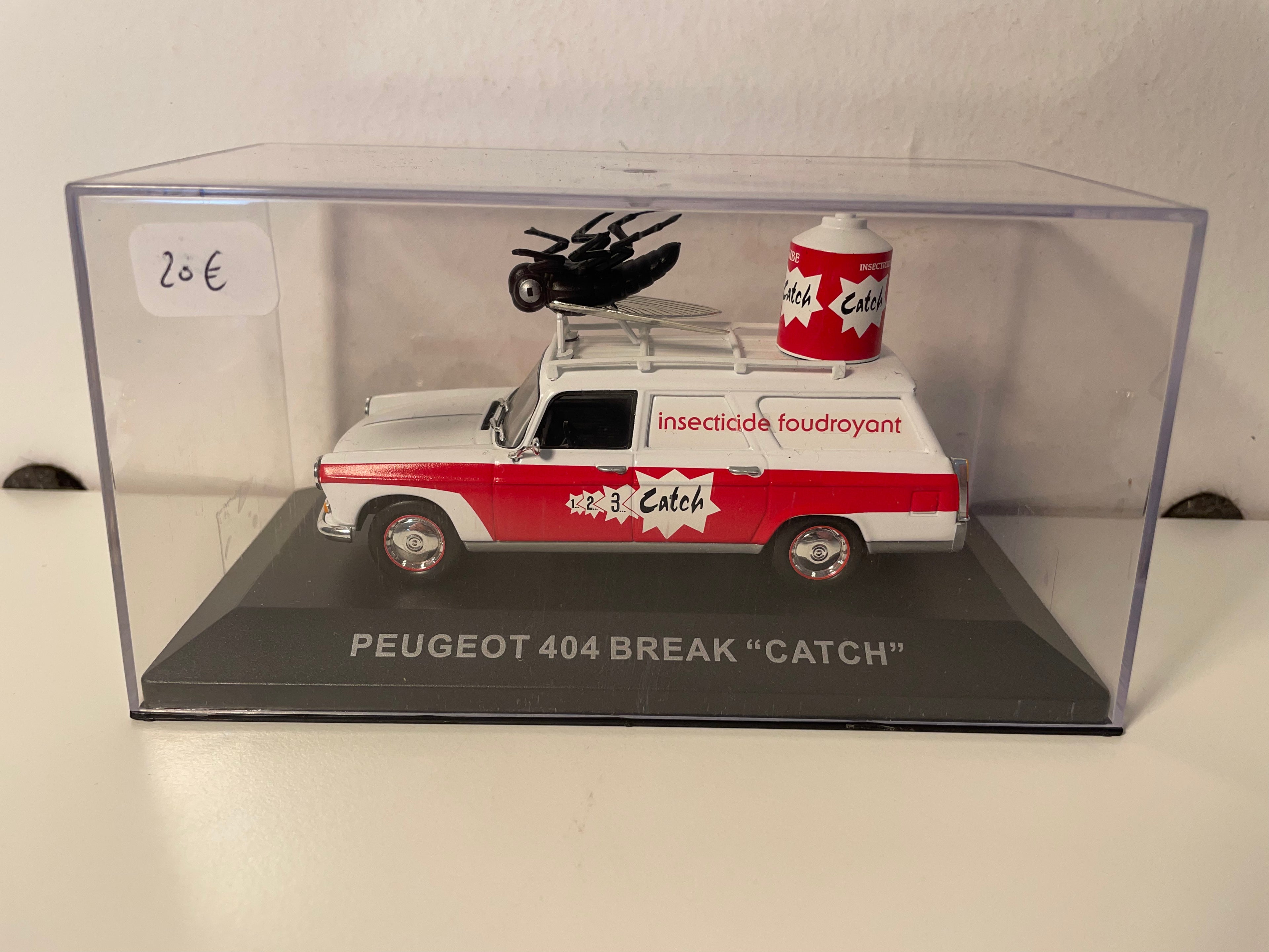 Peugeot 404 familiar blanco y rojo con publicidad CATCH