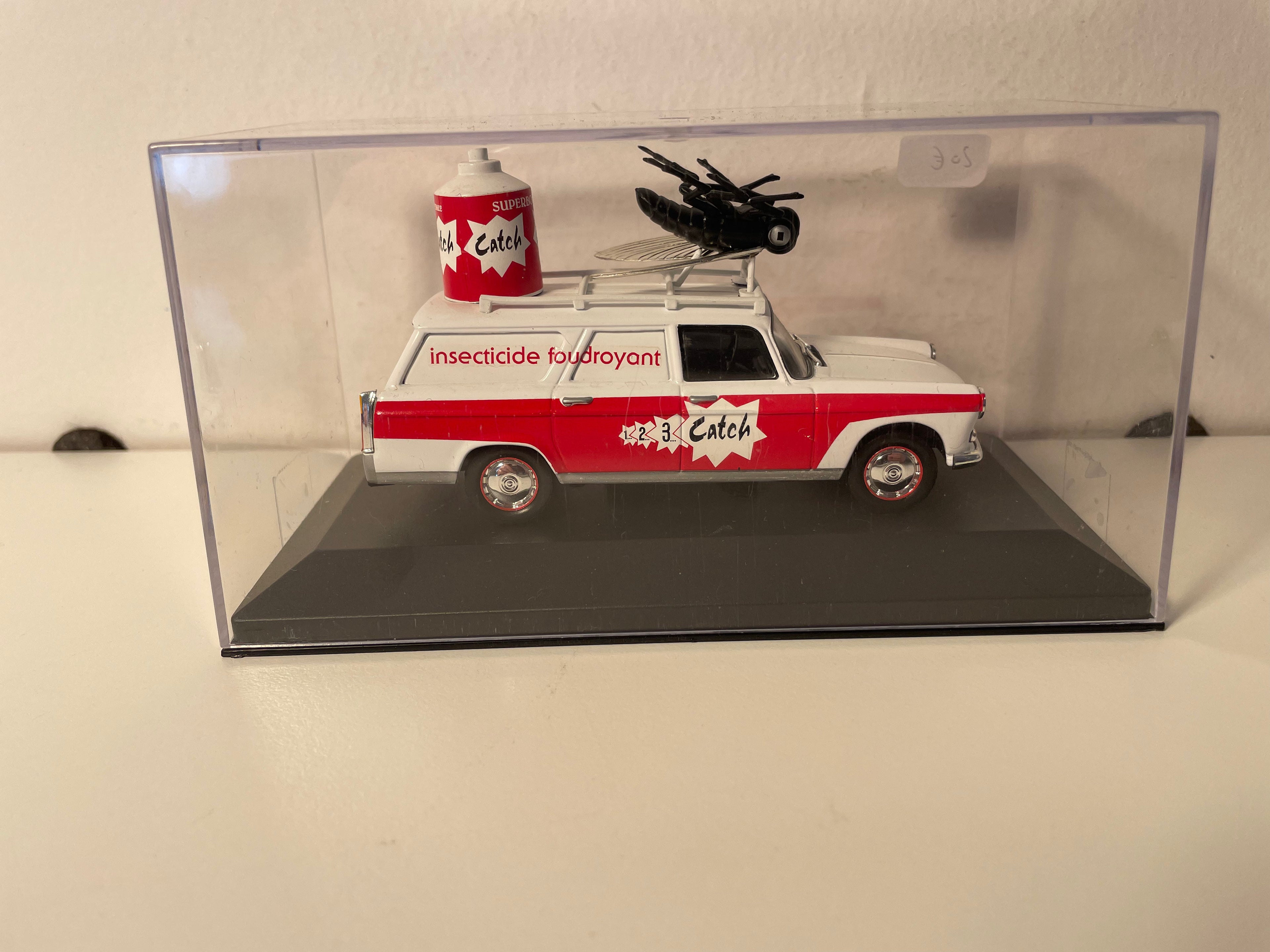 Peugeot 404 familiar blanco y rojo con publicidad CATCH