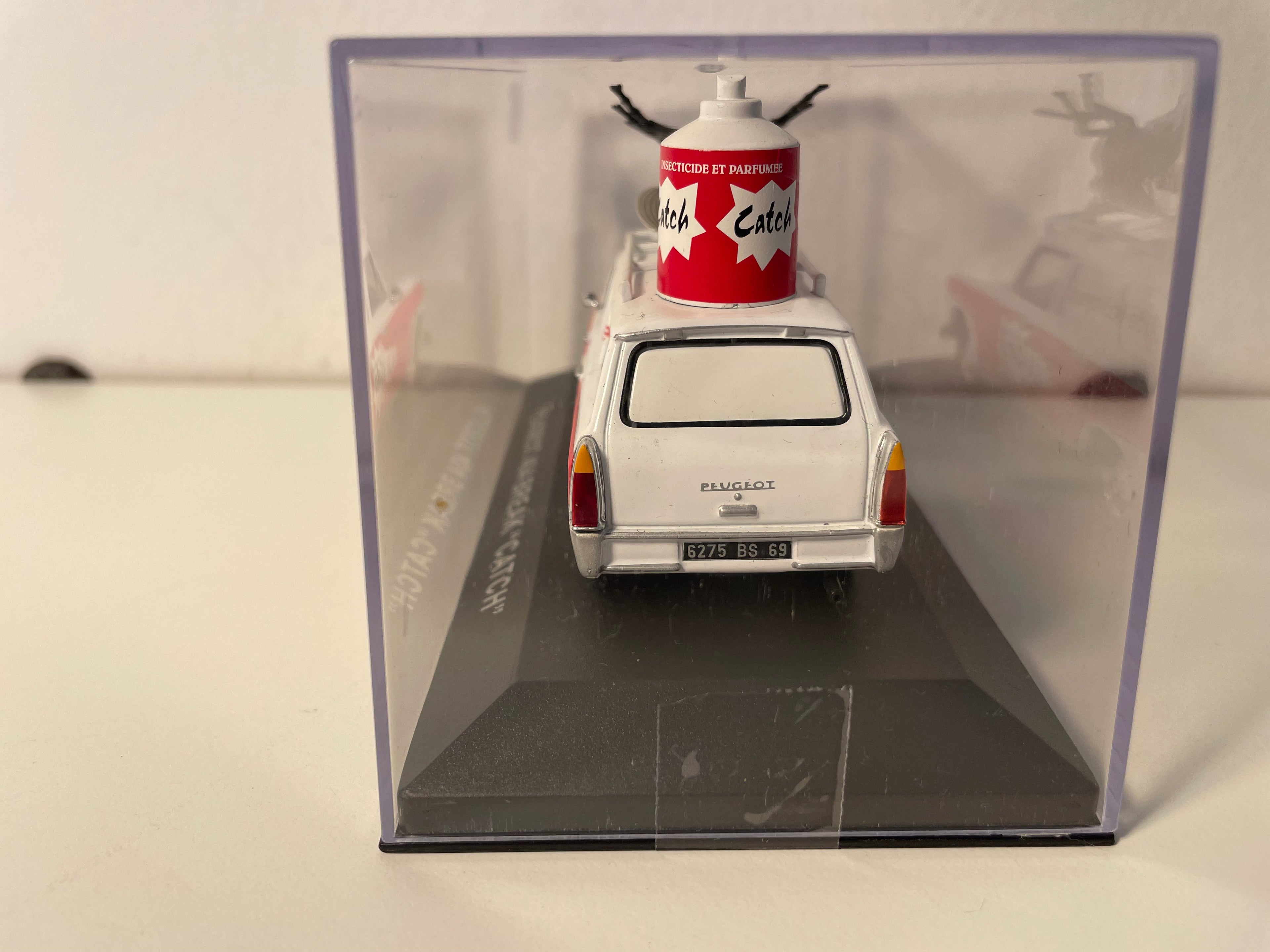Peugeot 404 familiar blanco y rojo con publicidad CATCH