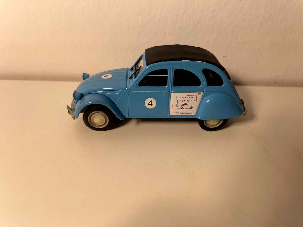 Citroën 2 CV 6 blu e tetto nero con il numero 4 e una pubblicità per l'agenzia di eventi "4 ruote sotto un ombrello" - Norev