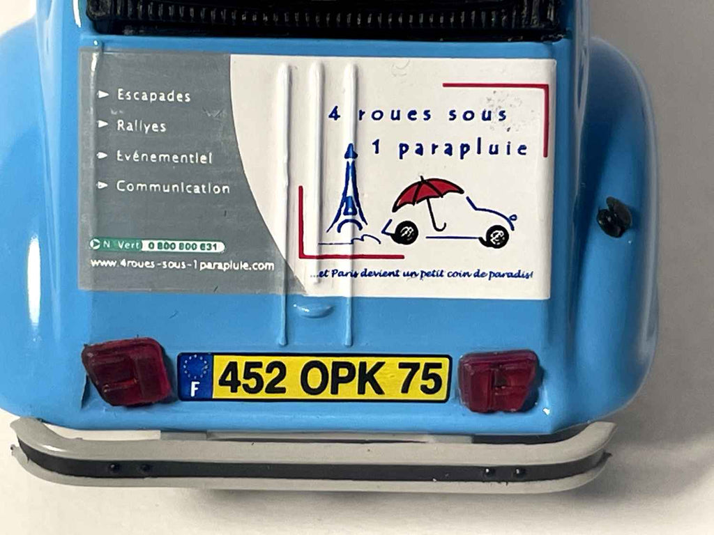 Citroën 2 CV 6 blu e tetto nero con il numero 4 e una pubblicità per l'agenzia di eventi "4 ruote sotto un ombrello" - Norev