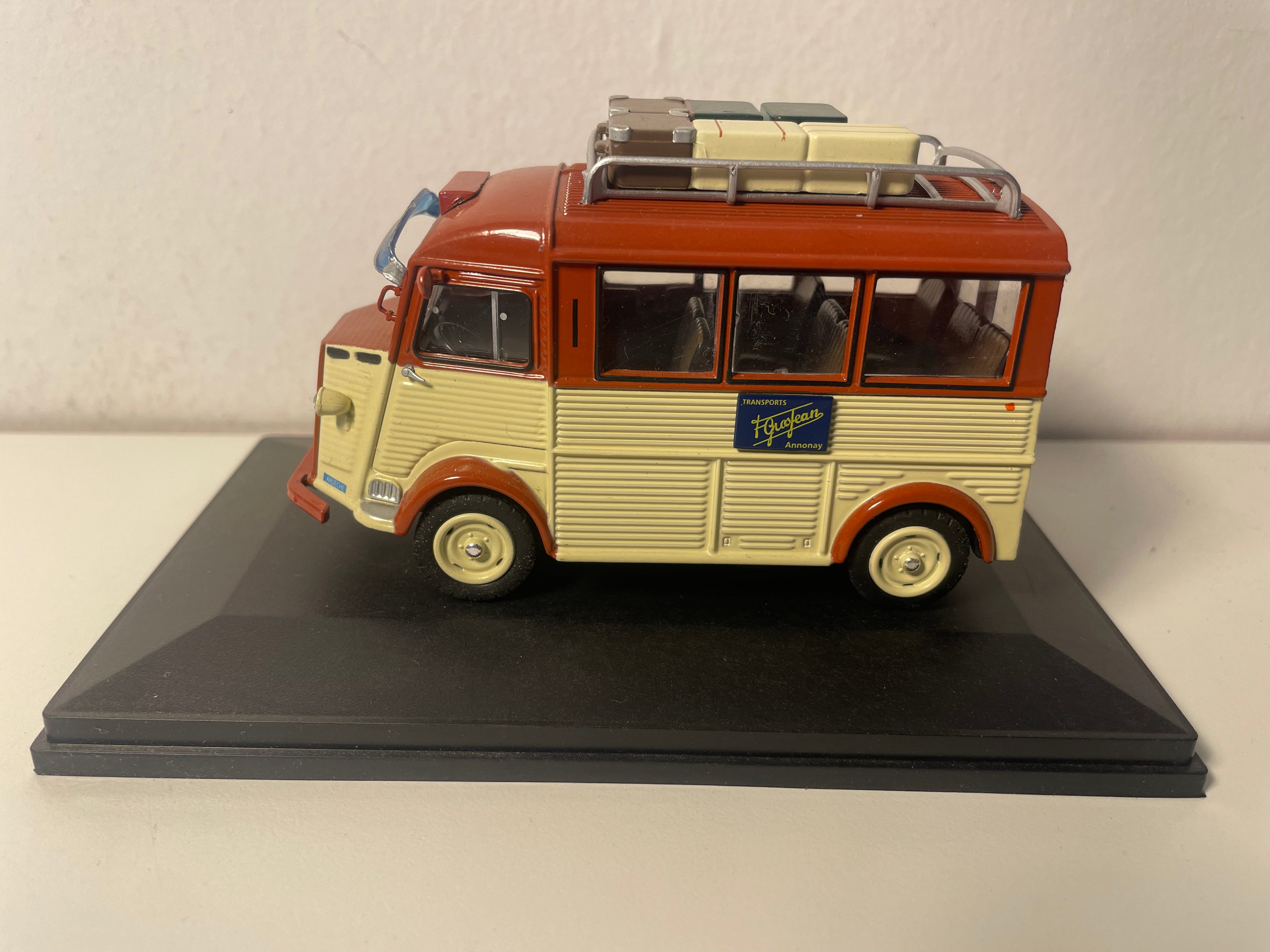 Beige en bruine Citroën Type H touringcar uit 1952 met bagage op het dak