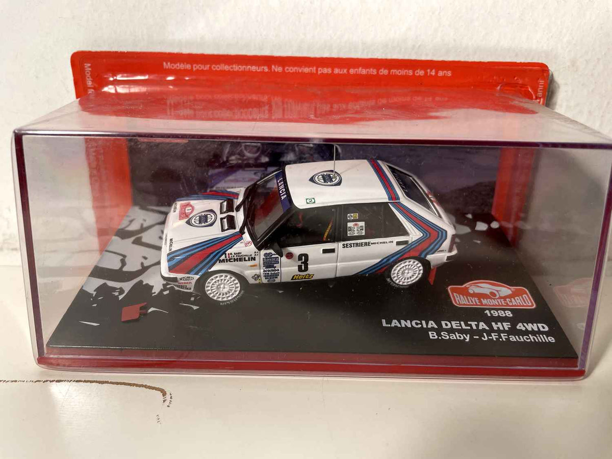 Lancia Delta HF 4WD wäiss, blo a rout nummer 3 (Rallye de Monte-Carlo 1988)