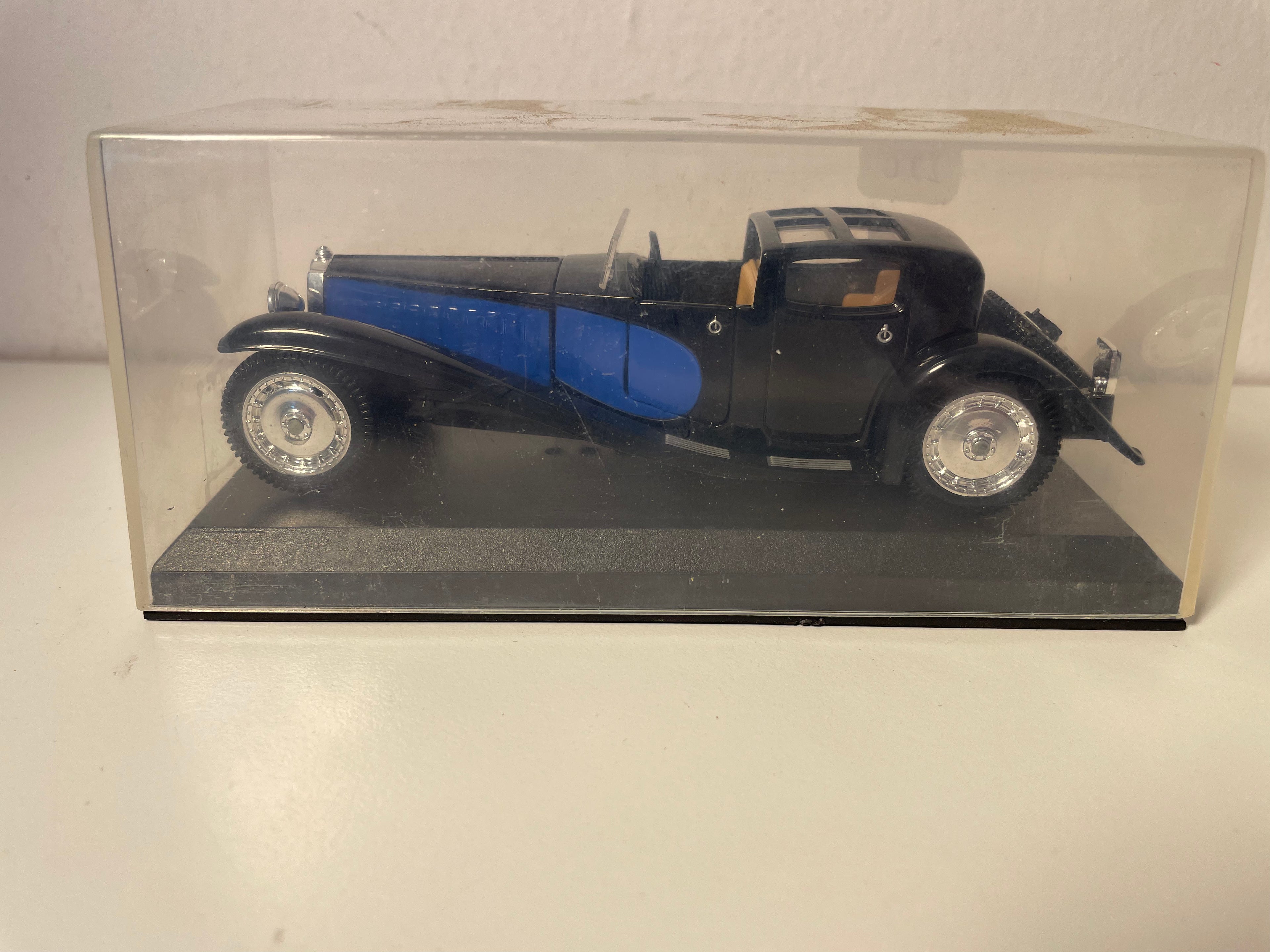 1928 blo-schwaarz Bugatti Royale (mat engem Nummschëld op enger gëllener Plack um Fouss)