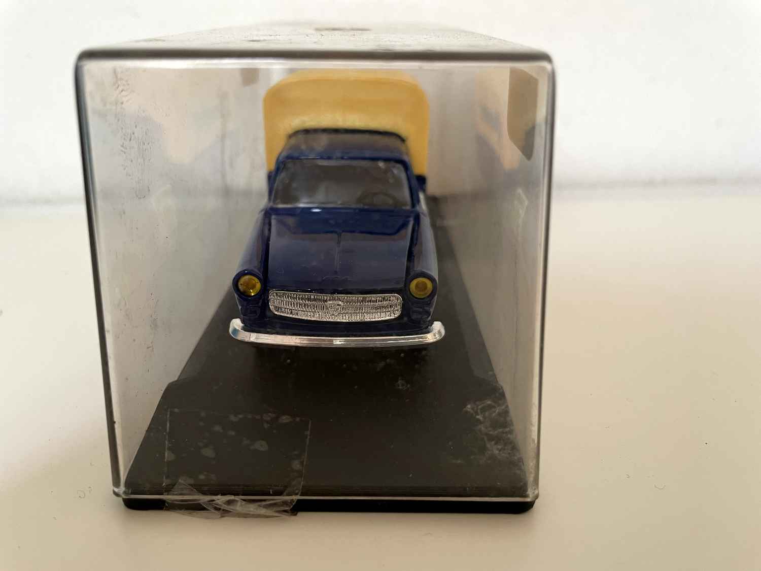 Peugeot 404 bâchée bleue et jaune avec le logo "l'aventure Peugeot" sur les portières (Eligor)